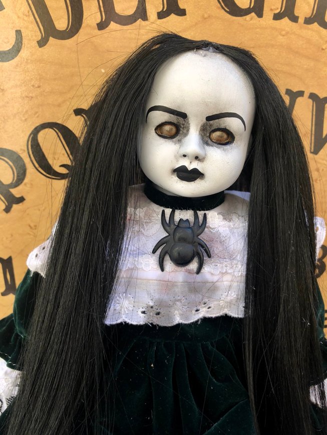 creepy girl with black hair and doll